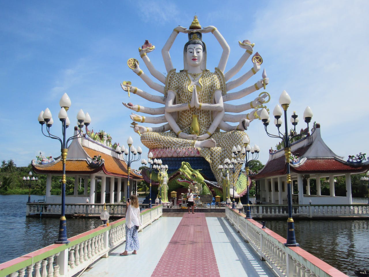 Captivating view of a multi-armed Buddhist statue at a temple in Thailand, signifying spirituality.